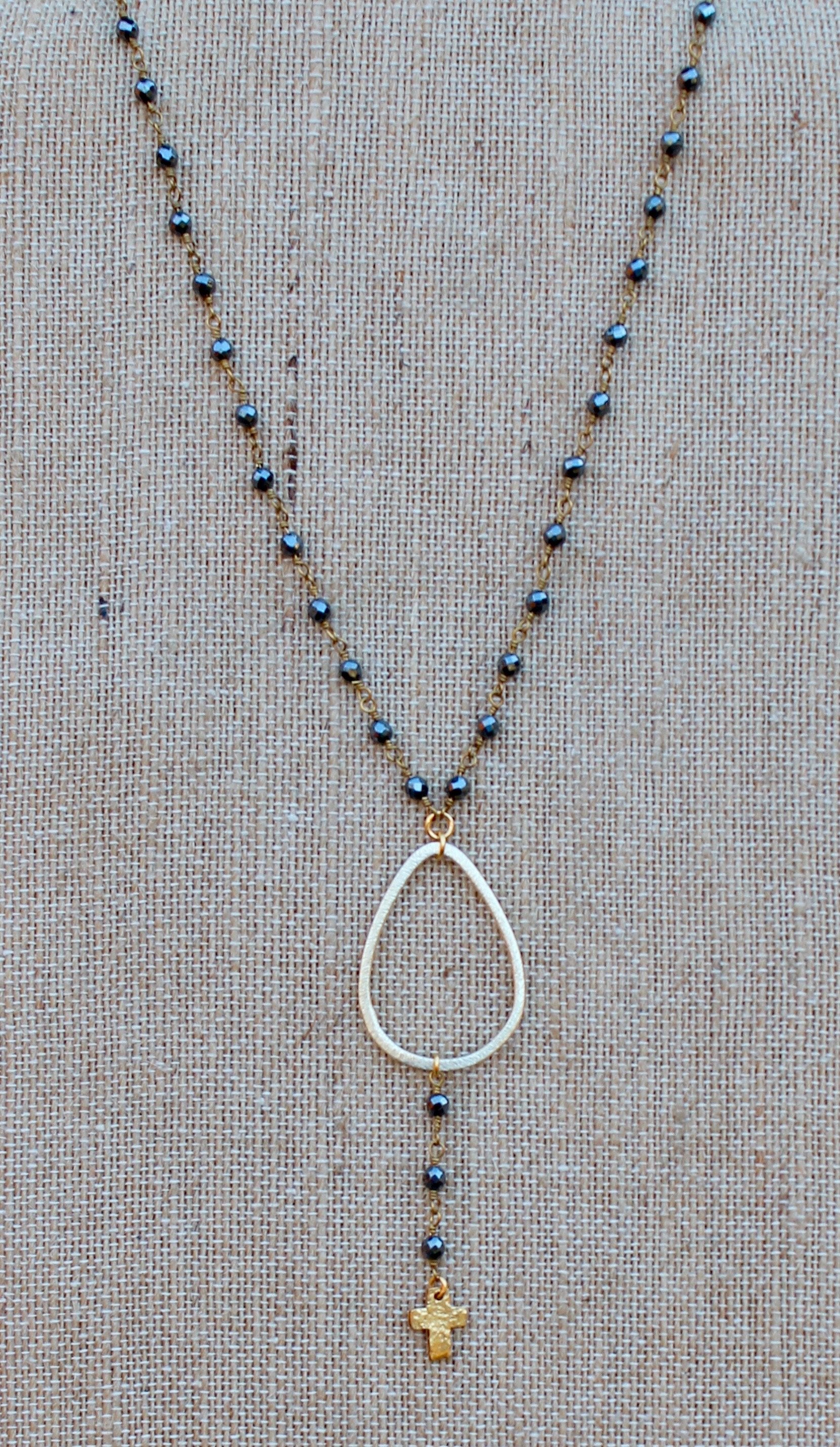 N145GH; Goldtone Teardrop; Tiny Cross on Drop; Goldtone Hematite Chain; Approximately 17 inches; ; ; Majestees